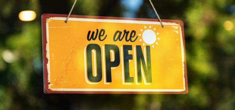 Local SEO: Getting the Most From Your Google Business Profile A yellow 'we are open' sign hanging in a shop window